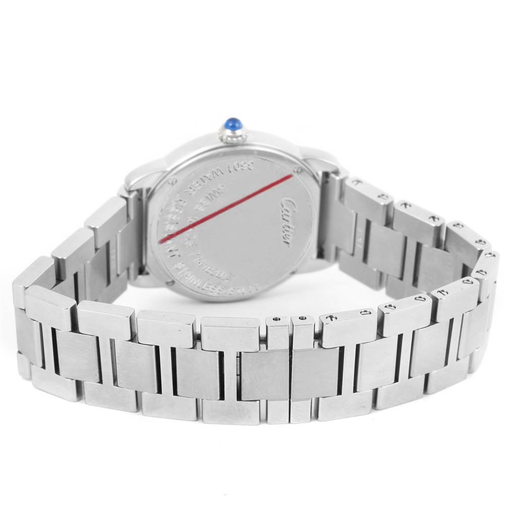The image shows the back and bracelet of a Ronde model by Cartier, highlighting its stainless steel finish and blue cabochon crown.
