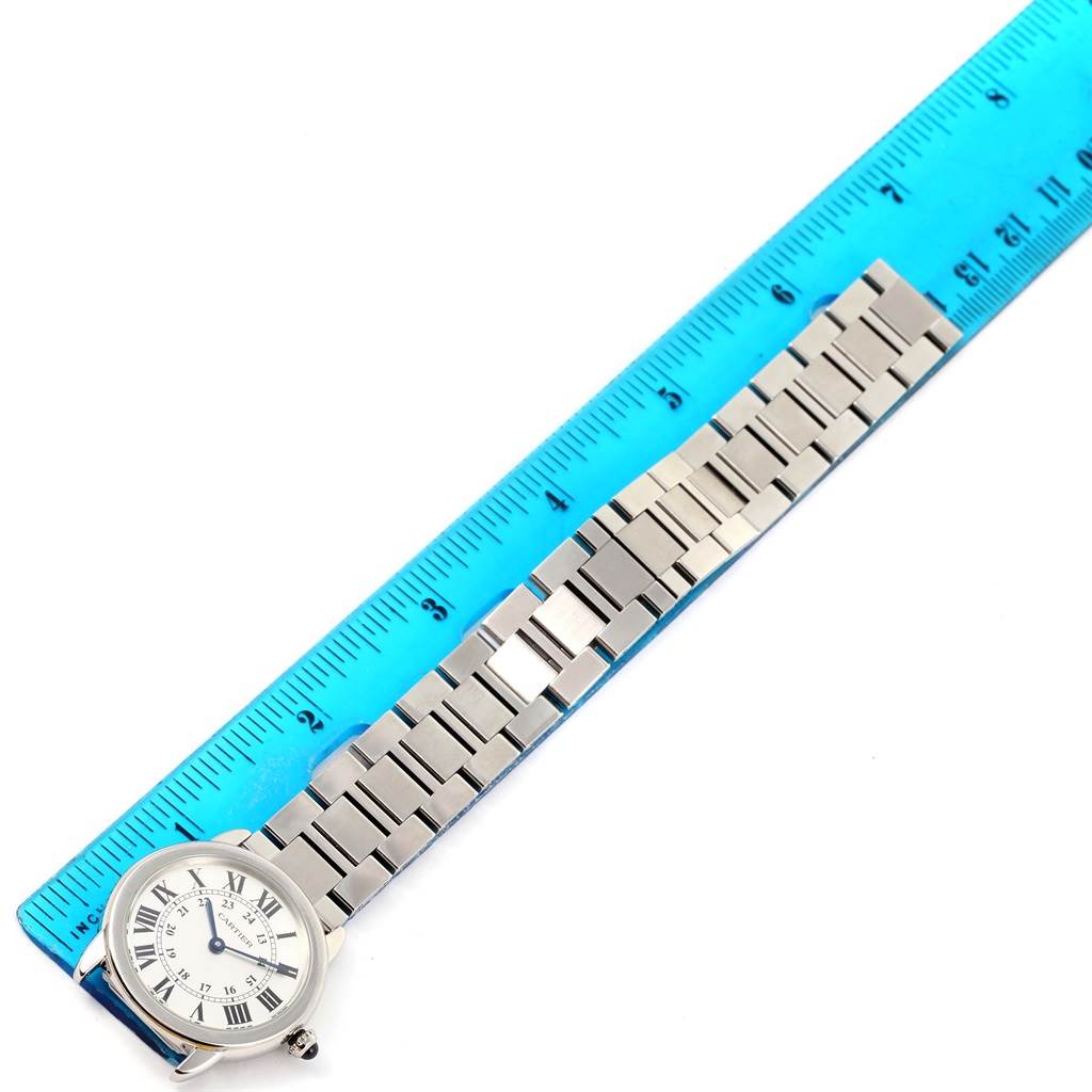 The image shows a Ronde model by Cartier, captured from a top-down angle alongside a blue ruler to measure the watch
s bracelet.
