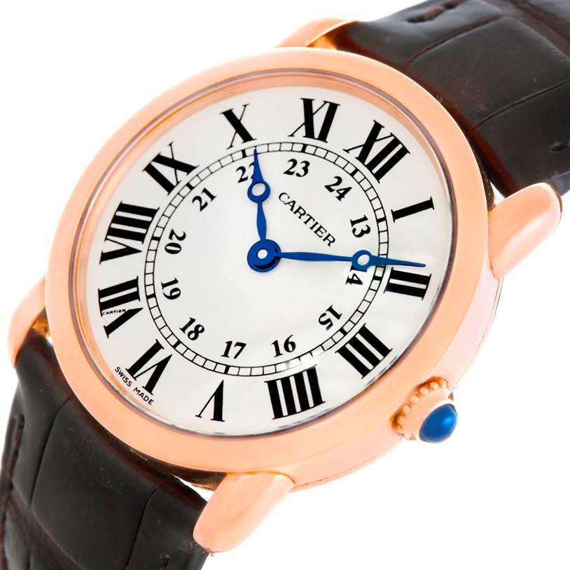 The Cartier Ronde W6800151 Women
s Rose Gold Silver Dial W6800151 Women
s Rose Gold Silver Dial watch is shown at a slight angle, highlighting its face, Roman numerals, blue hands, and part of the leather strap.