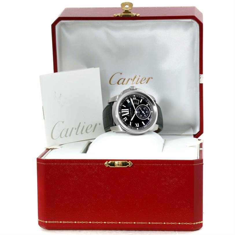 The Calibre de Cartier watch by Cartier is displayed in an open box with a booklet inside.
