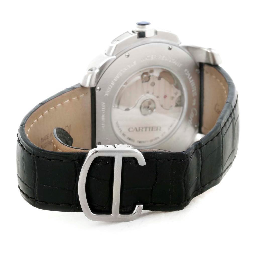 The image shows the back and strap of a Calibre de Cartier watch by Cartier, highlighting its deployment clasp and see-through case back.