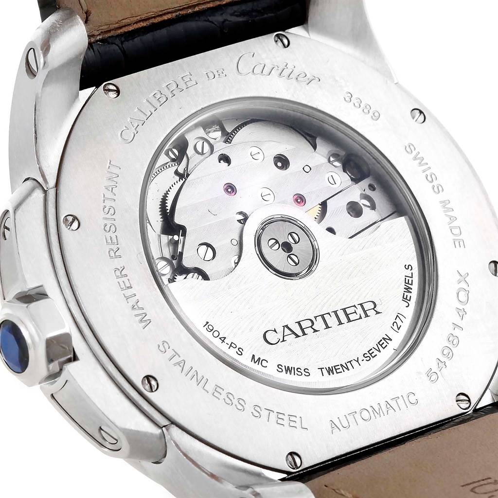 The image shows the back of a Calibre de Cartier watch by Cartier, revealing its mechanical movement and inner engravings.