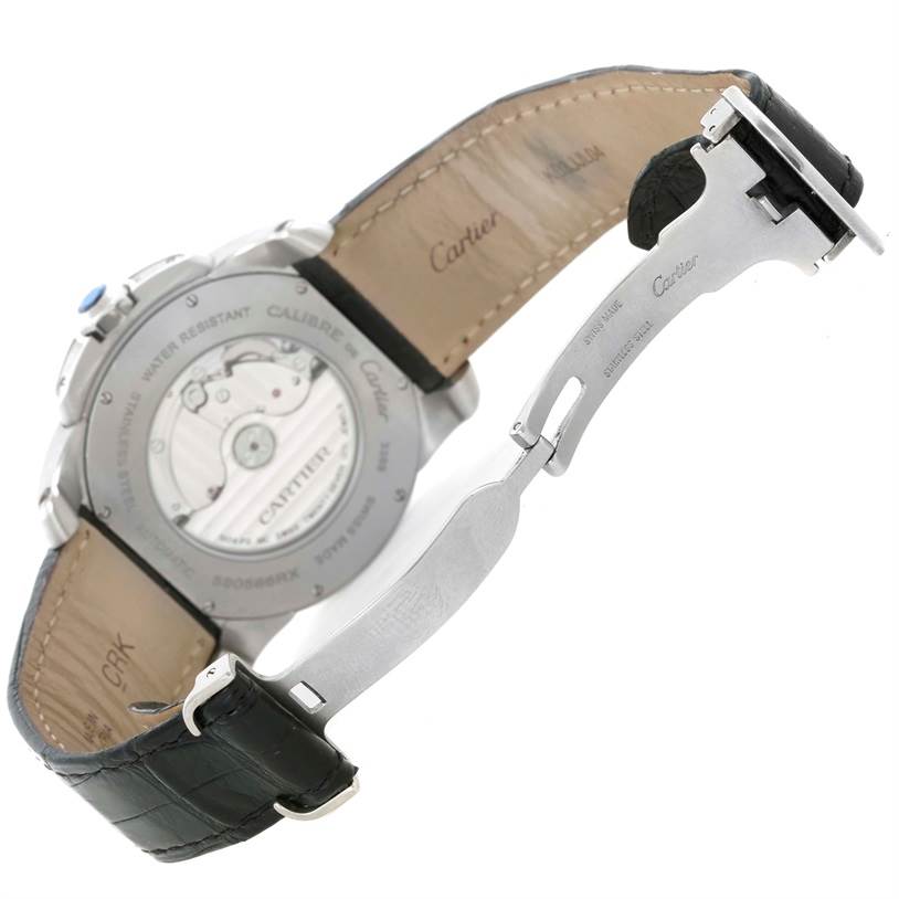 The image shows the back view of the Calibre de Cartier watch by Cartier, including its movement, leather strap, and deployment clasp.