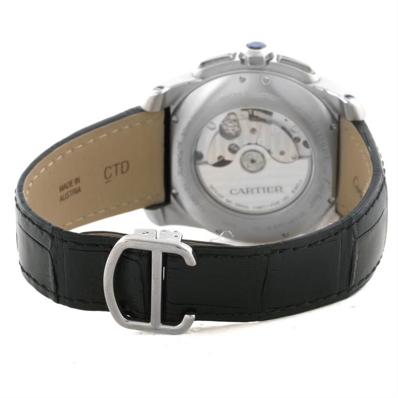 The image shows the back view of the Calibre de Cartier watch by Cartier, highlighting the transparent case back and leather strap.