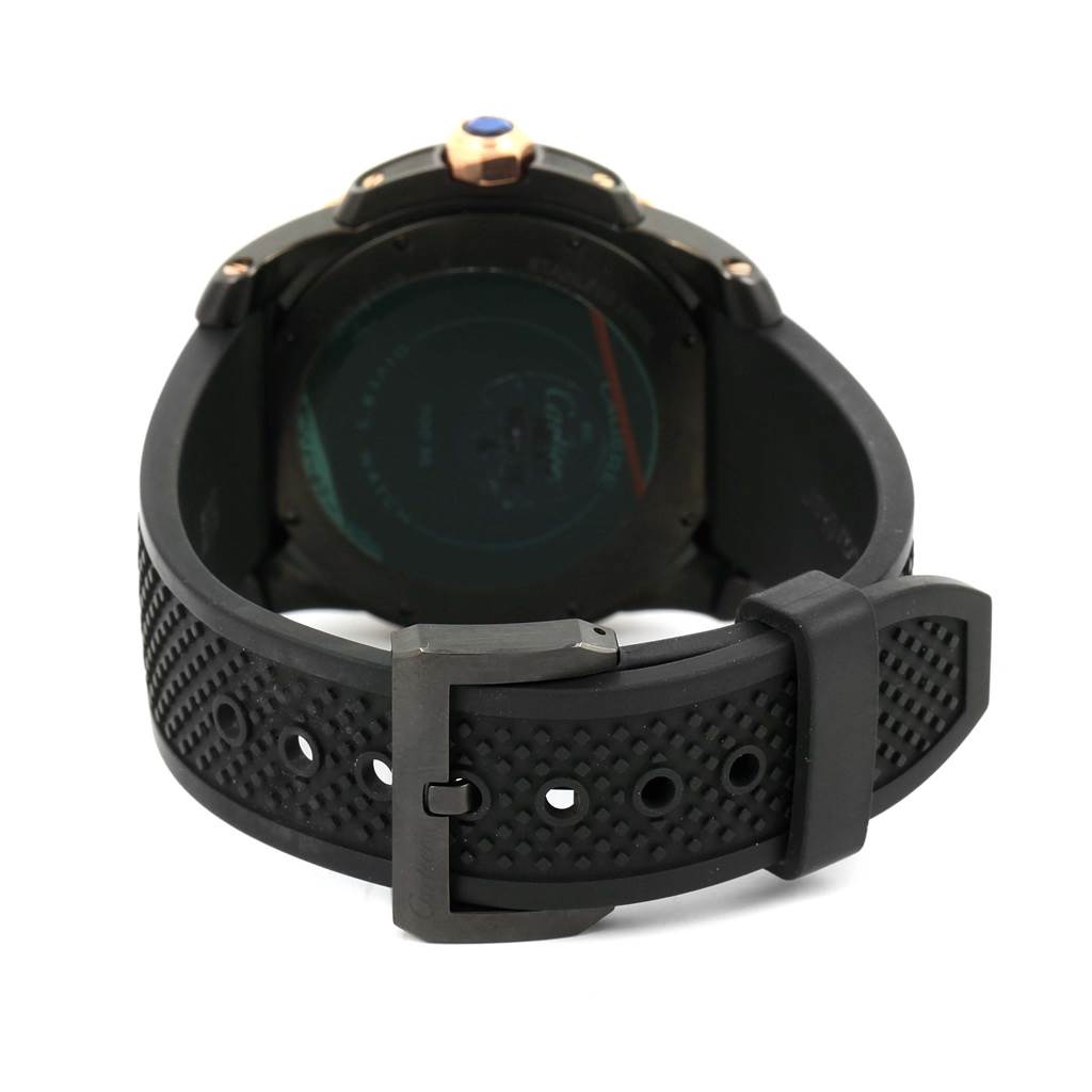 The image shows the back view of a Calibre de Cartier watch by Cartier, focusing on the case back and rubber strap with a buckle.