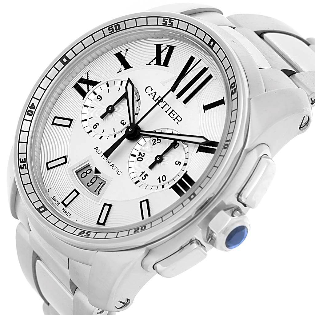The image shows a Calibre de Cartier watch by Cartier at an oblique angle highlighting the dial, crown, and part of the stainless steel band.