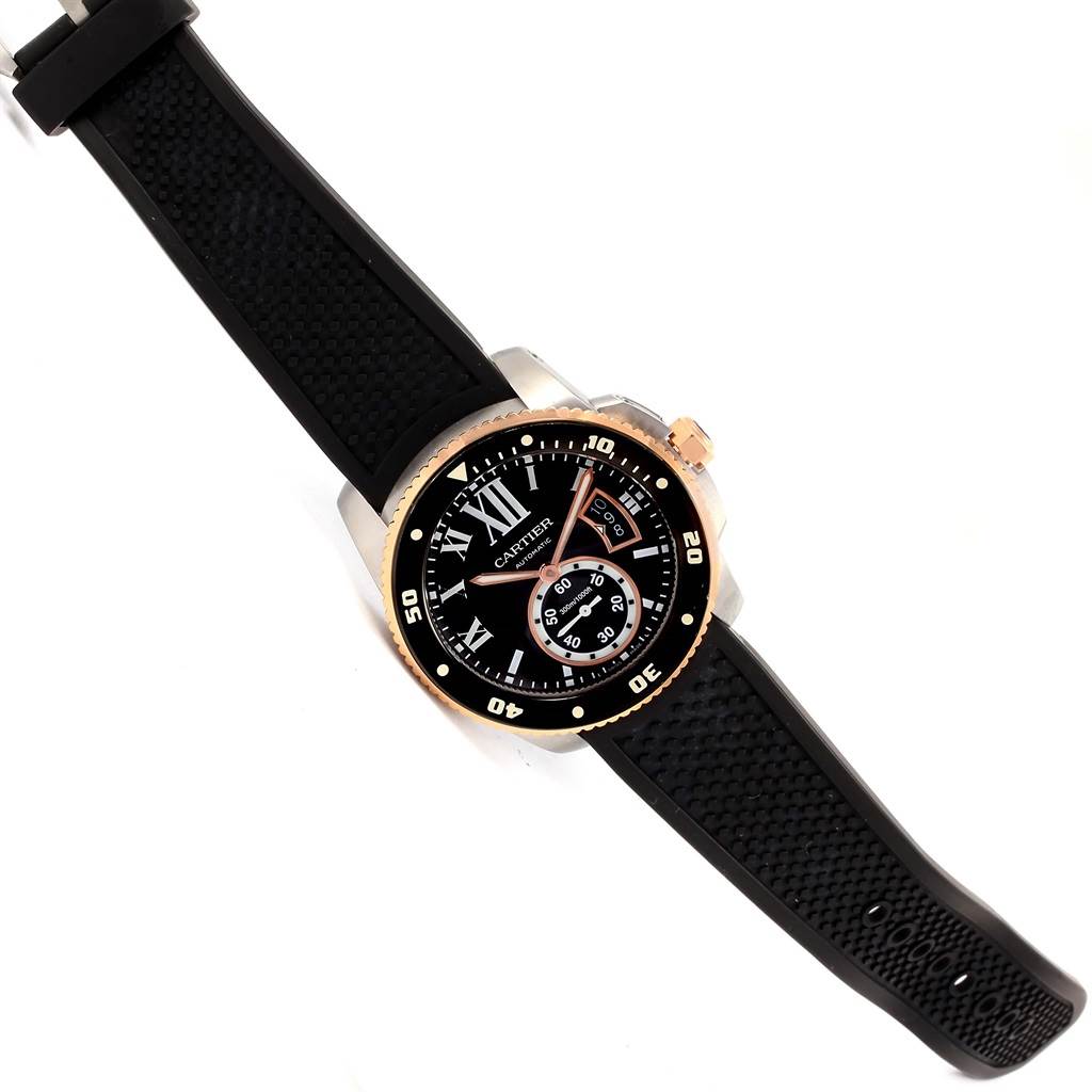 The Calibre de Cartier watch by Cartier is shown at a top-down angle, displaying its face, dial, numerals, and rubber strap.
