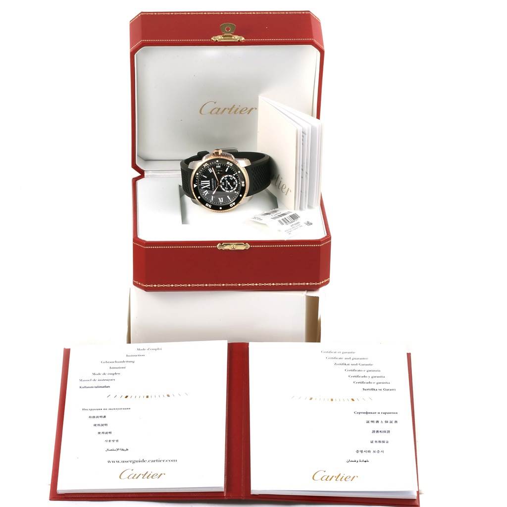 The image shows a Calibre de Cartier watch by Cartier in an open box with accompanying booklets and labels on the side.