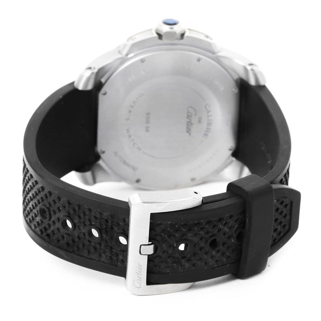This image shows the back view of a Calibre de Cartier watch by Cartier, displaying the case back and black rubber strap with buckle.