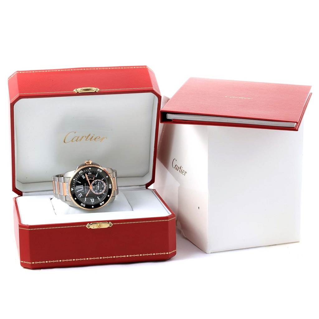 The image shows a Calibre de Cartier watch by Cartier in an open red presentation box with additional packaging beside it.
