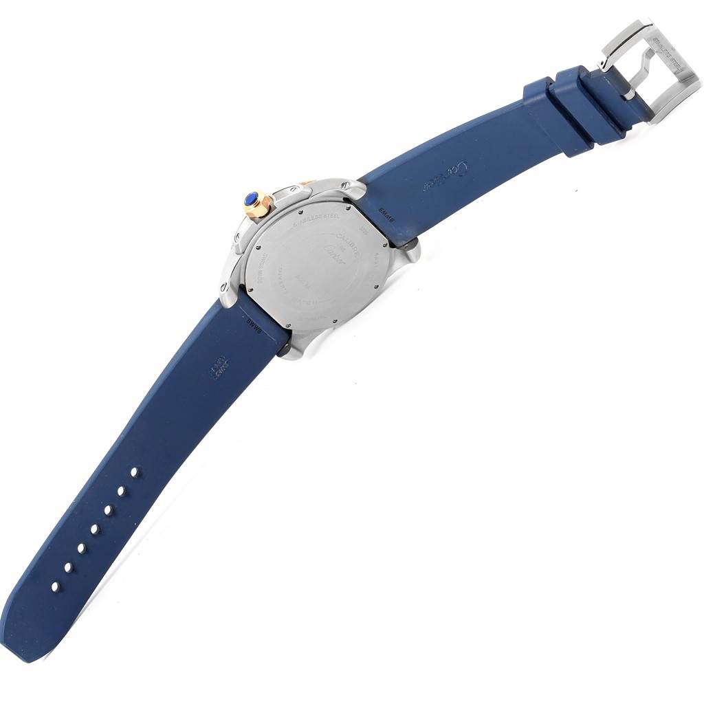 The image shows the back view of a Calibre de Cartier watch by Cartier, displaying its blue strap, clasp, and back case.