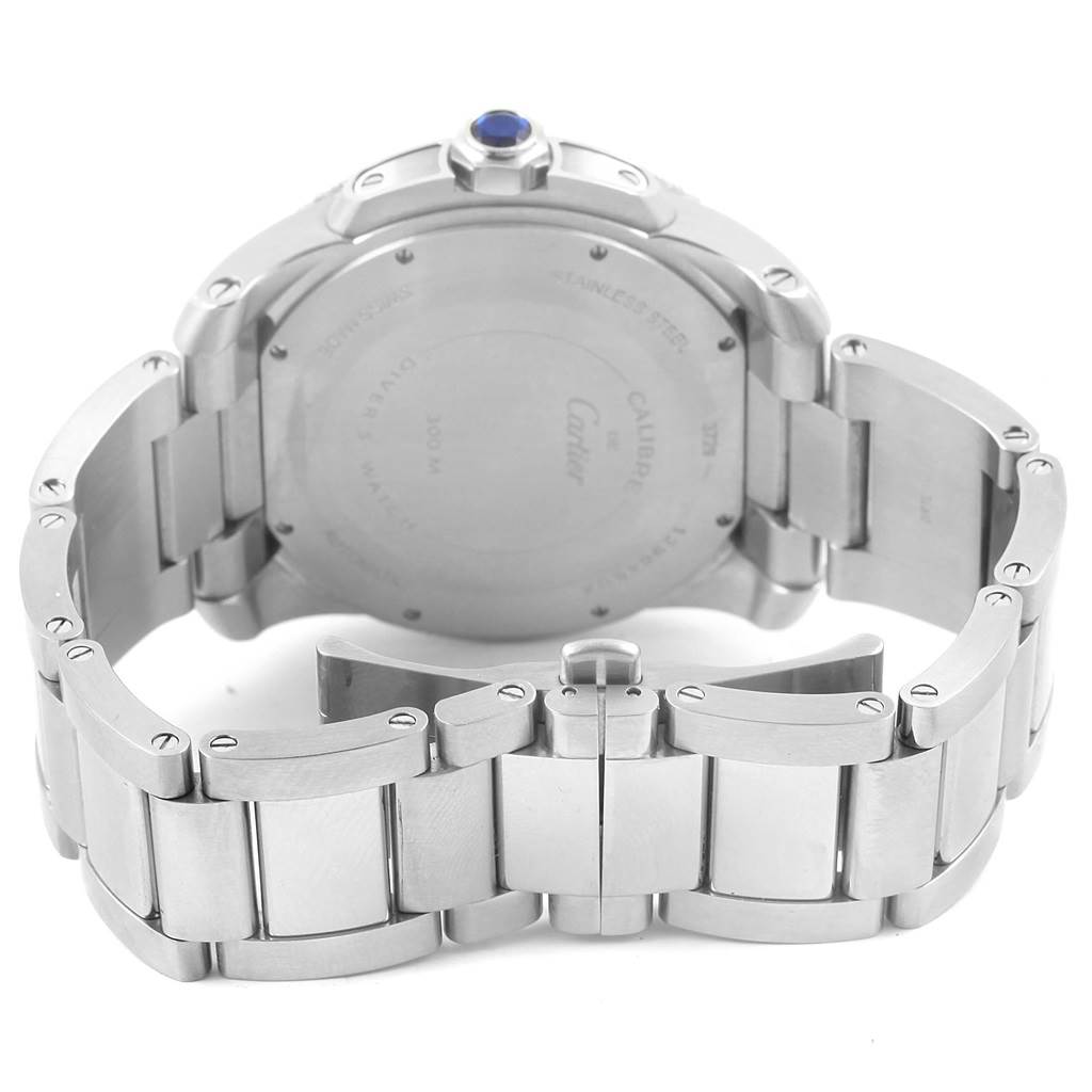 The image shows the back view of a Calibre de Cartier watch by Cartier, focusing on the case back and metal bracelet.