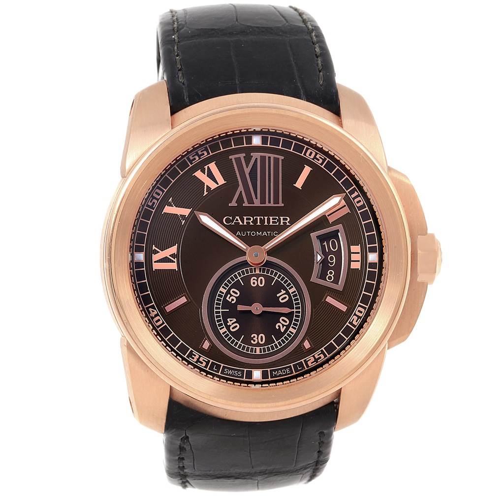 The image shows a frontal view of a Calibre de Cartier watch by Cartier, displaying the dial, hour markers, hands, and date.