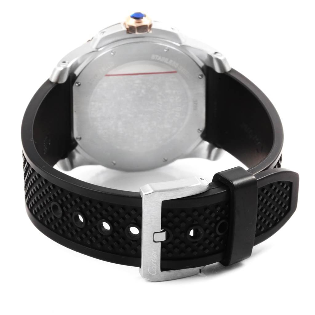The image shows the back of the Calibre de Cartier watch by Cartier, featuring the case back and black rubber strap with a buckle.