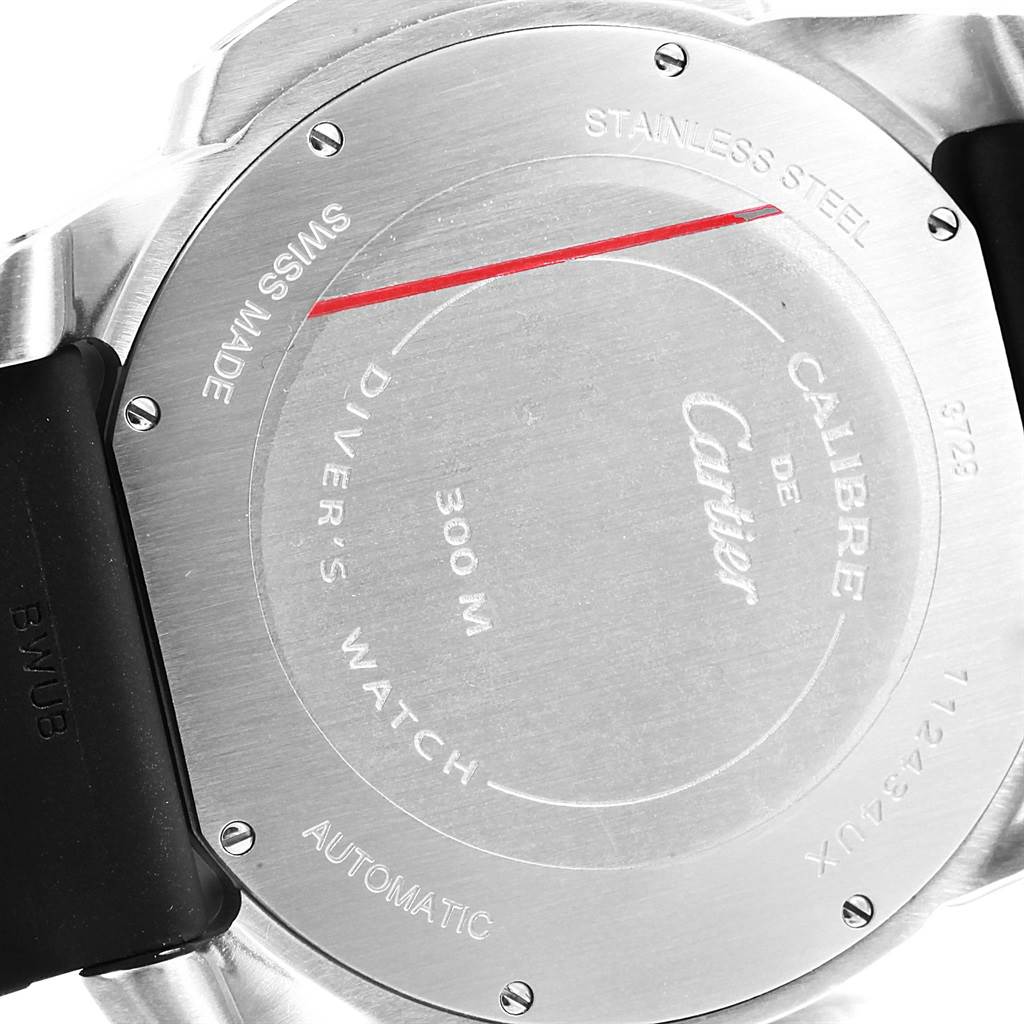 The image shows the back of a Calibre de Cartier watch by Cartier, highlighting the stainless steel case and engravings.