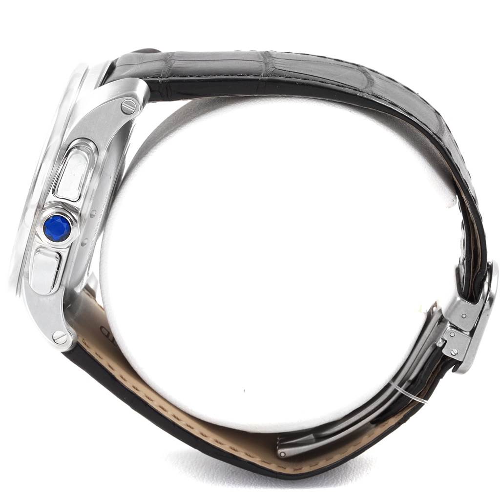 This side profile shows the case, crown with blue cabochon, pushers, and black leather strap of the Calibre de Cartier watch by Cartier.