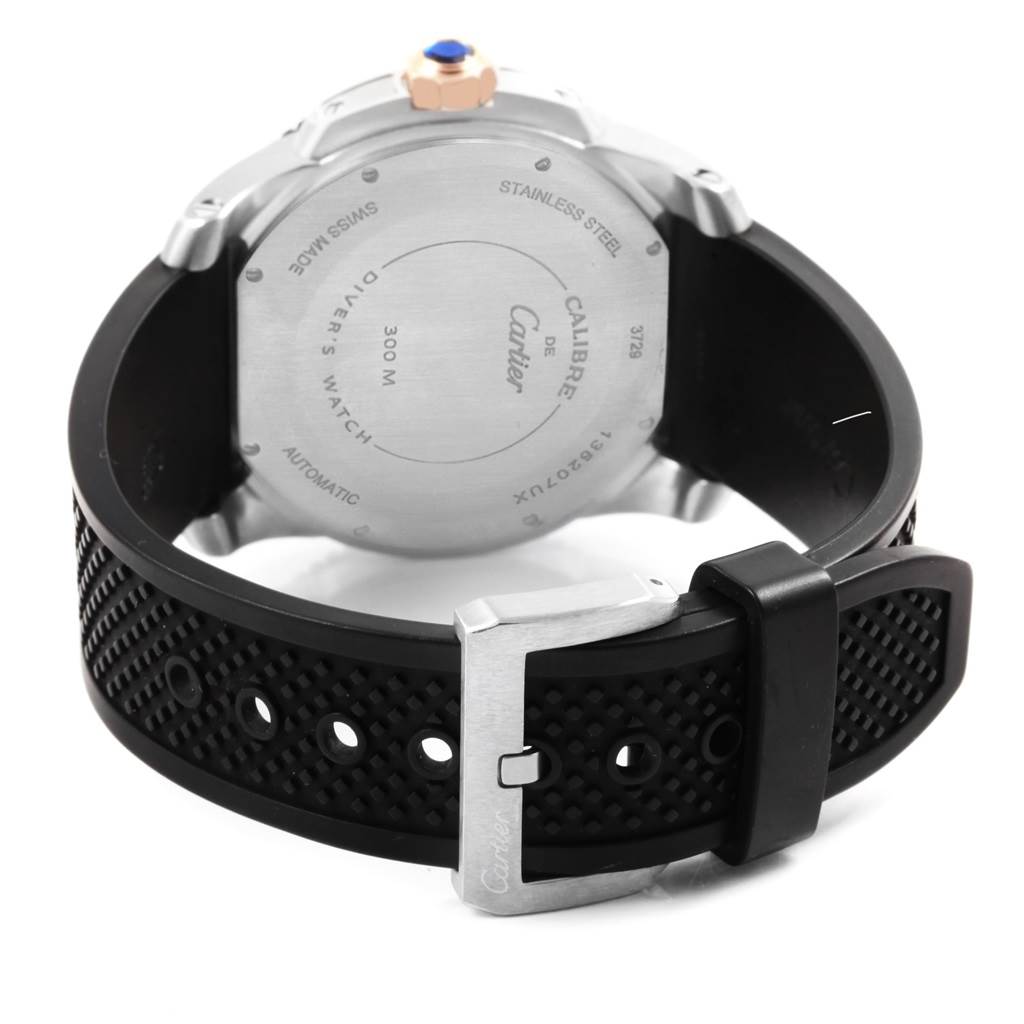 The image shows the back case and strap of a Calibre de Cartier watch, highlighting the stainless steel case and black rubber strap with buckle.