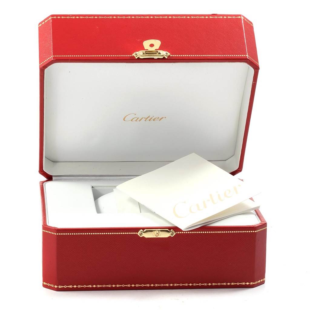 The image shows an open red Cartier watch box with "Cartier" printed inside the lid, and accompanying booklets for the Calibre de Cartier model.