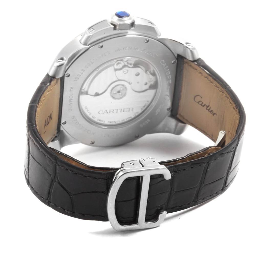 The image shows the back of a Calibre de Cartier watch by Cartier, highlighting the case back, the automatic movement, and the black leather strap with buckle.