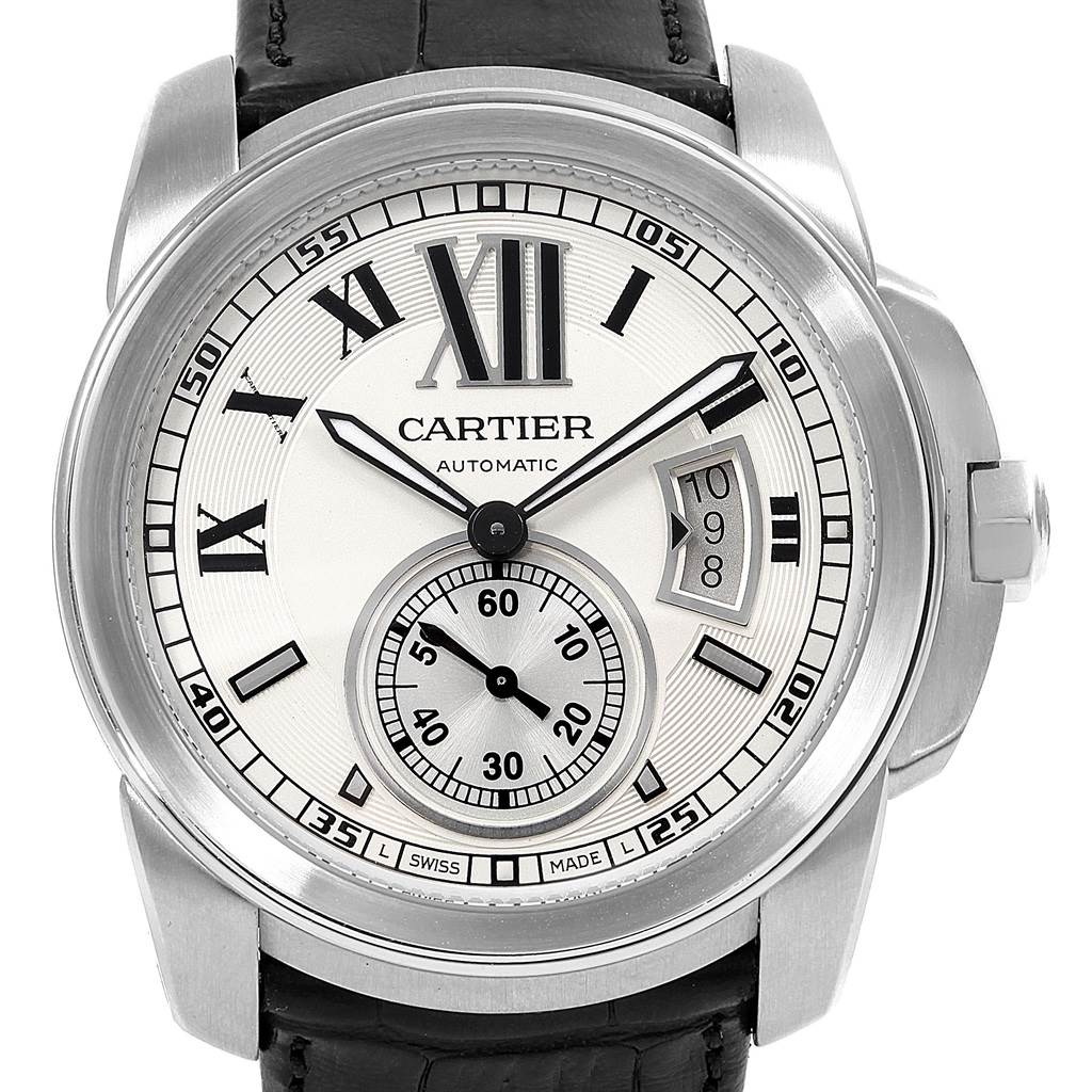 The image shows a front view of the Calibre de Cartier watch by Cartier, highlighting its dial, hour markers, and date window.