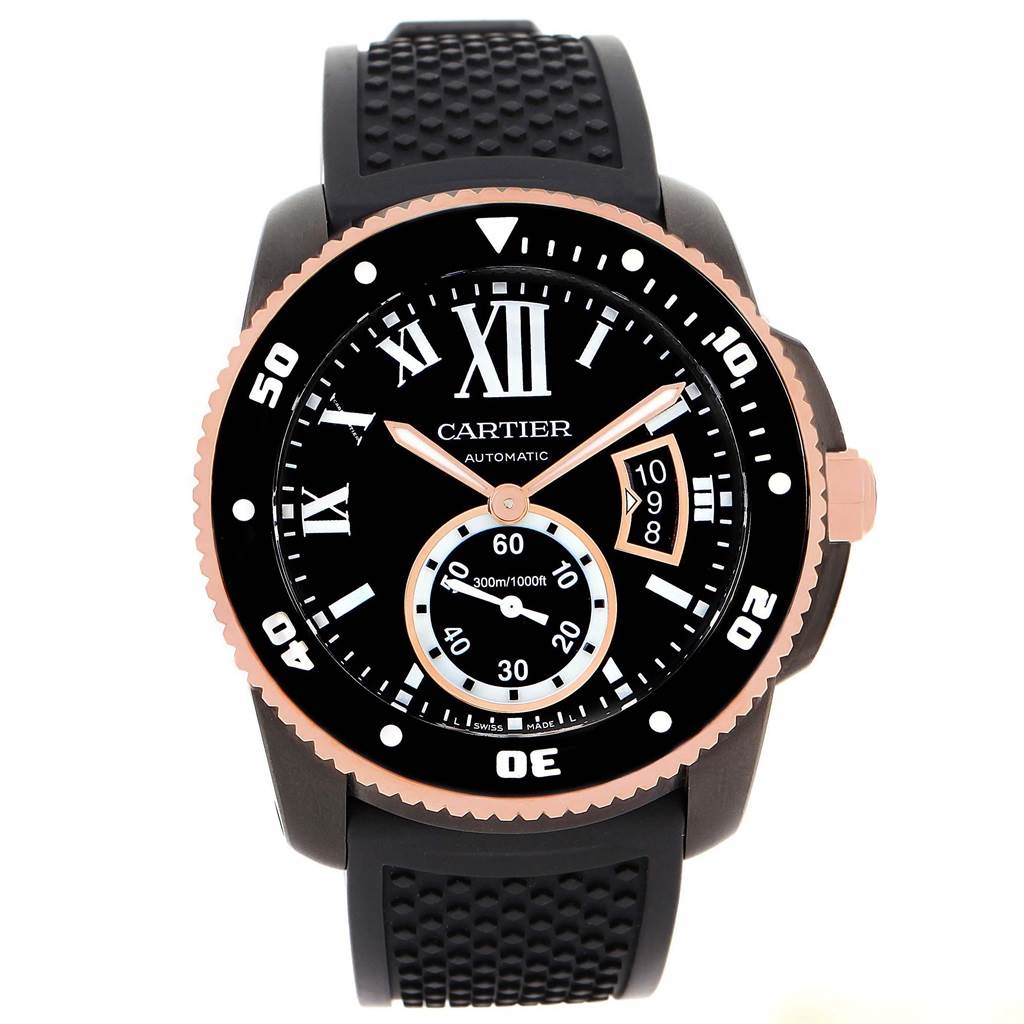 The image shows a front view of the Calibre de Cartier watch by Cartier, featuring its black dial, date window, and rubber strap.