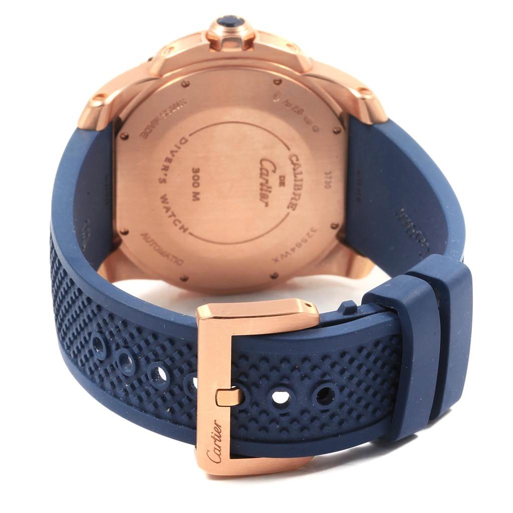 The image shows the back of the Calibre de Cartier watch with a blue strap and gold-tone buckle.