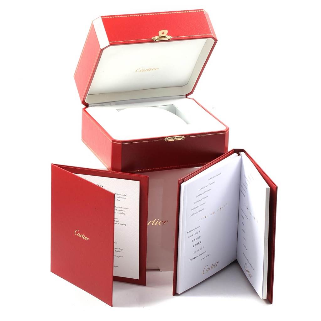 The image shows the red Cartier box and manuals for the Calibre de Cartier model by Cartier.