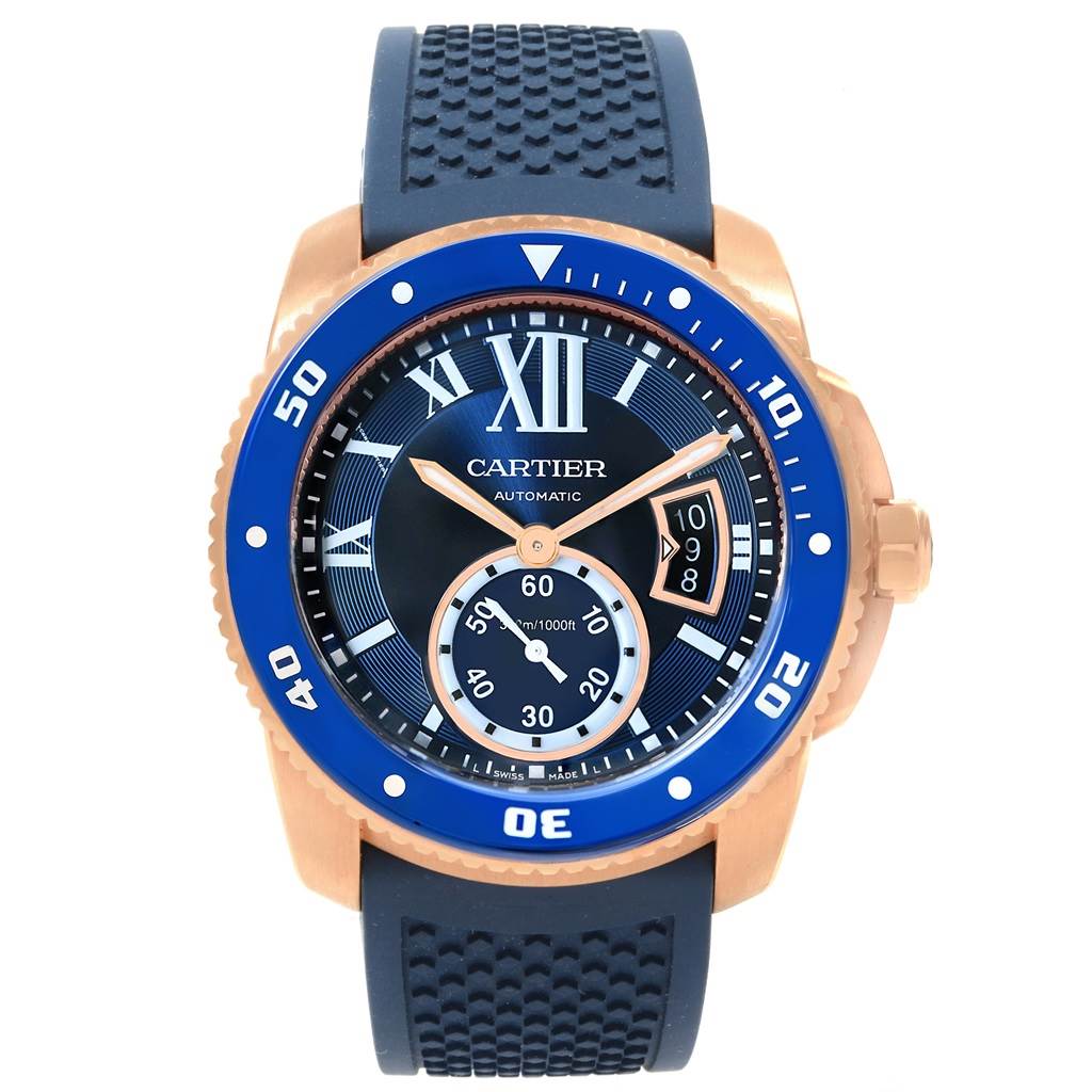 The image shows a front view of the Cartier Calibre de Cartier WGCA0010 Men's Rose Gold Blue Dial WGCA0010 Men's Rose Gold Blue Dial watch with a blue bezel and a black rubber strap.