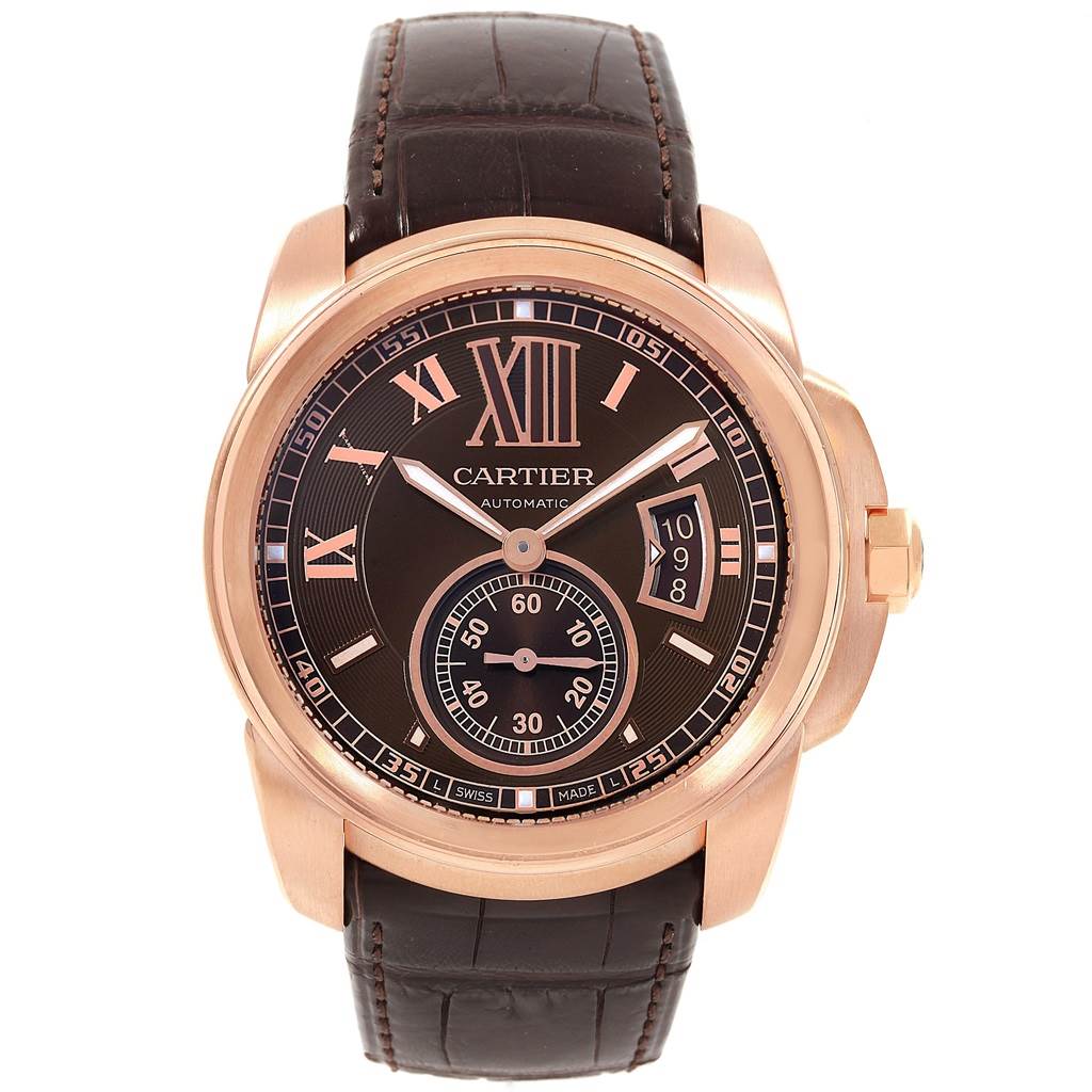 The image shows a front view of the Calibre de Cartier watch by Cartier, displaying its face, dial, and strap.