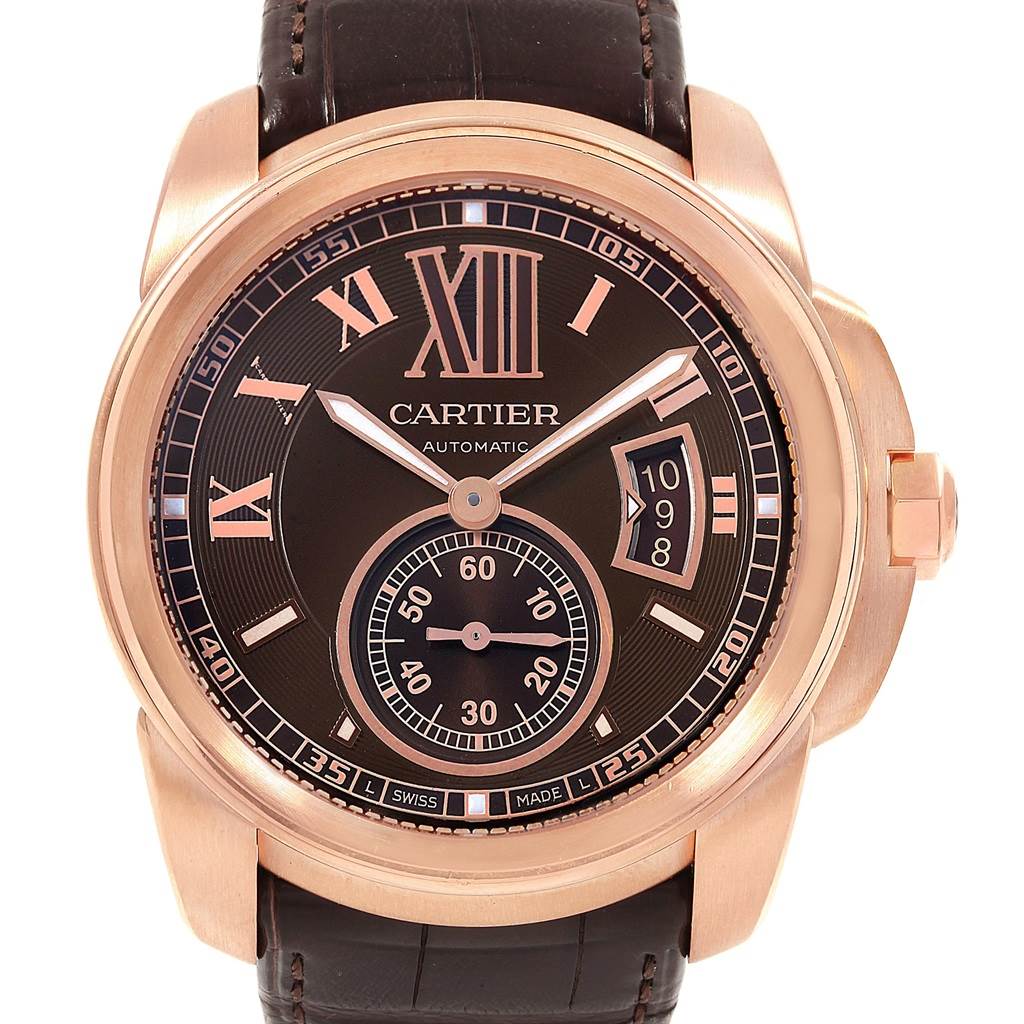 The image shows a front view of the Calibre de Cartier watch by Cartier, highlighting the face, numerals, hands, and date display.