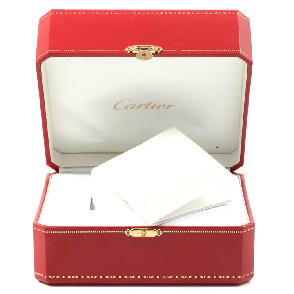 The image shows an open red Cartier box containing a white booklet for the Calibre de Cartier watch model.