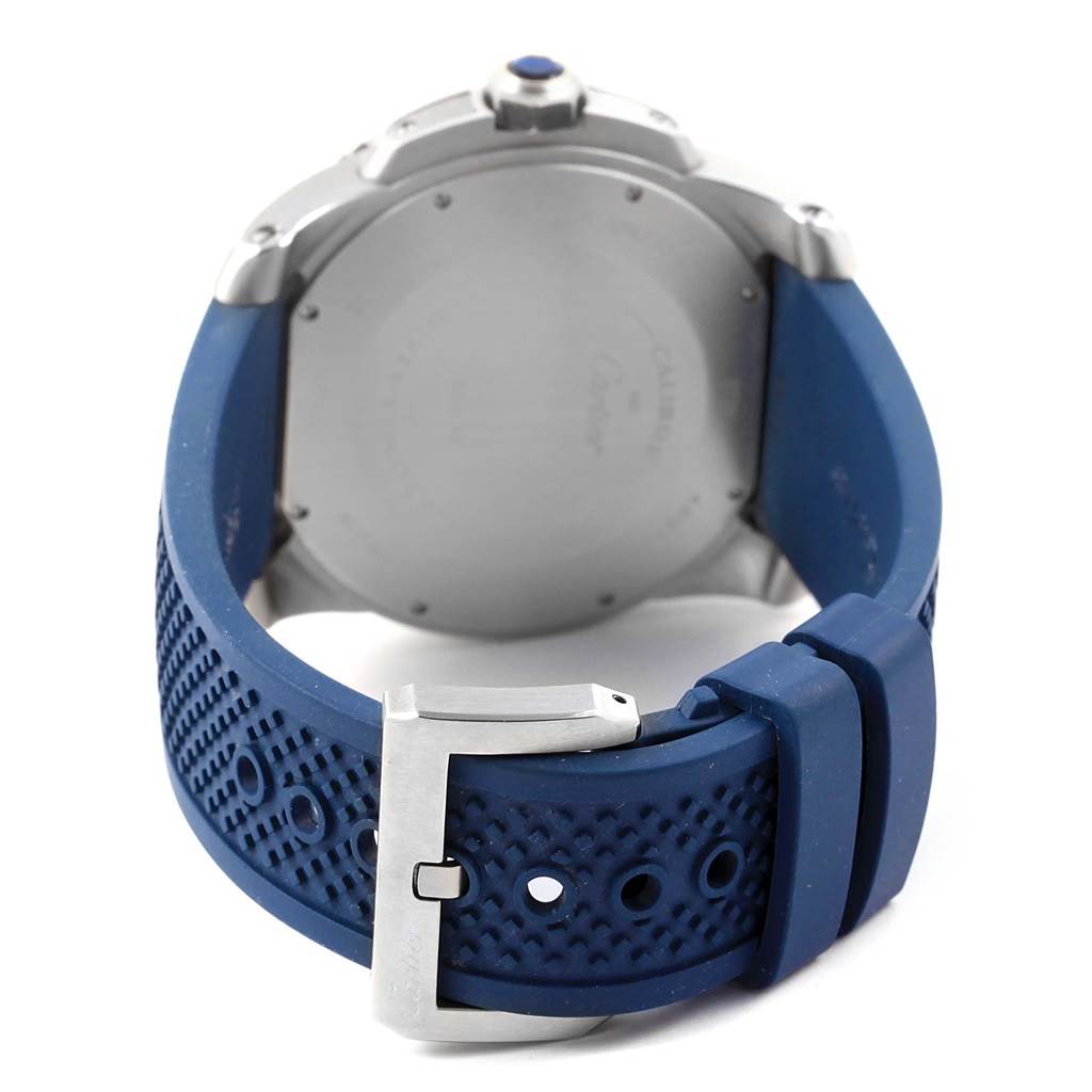 The image shows the back view of the Calibre de Cartier watch by Cartier, highlighting the blue strap and buckle.