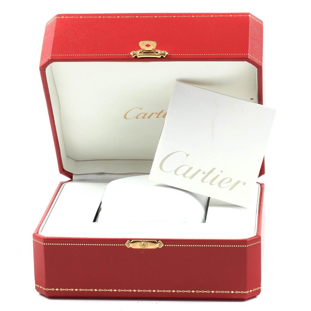 An open red Cartier box with a booklet inside, displaying the packaging for a Calibre de Cartier model.