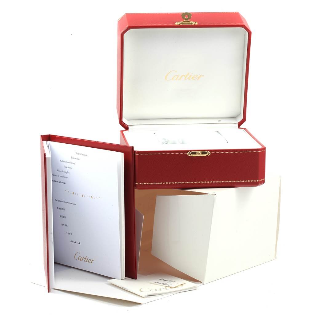 This image shows an open box, booklet, and packaging for the Calibre de Cartier watch by Cartier.