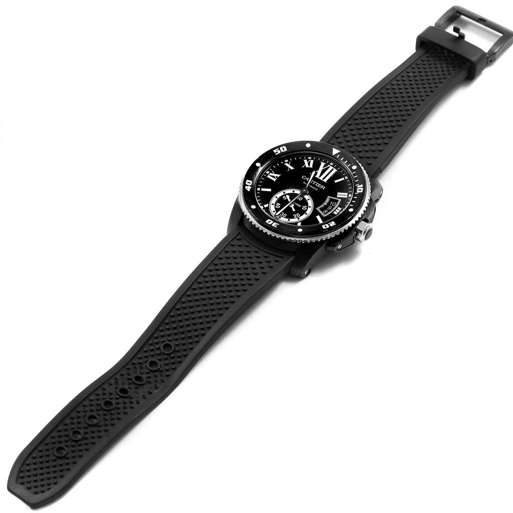 The image shows a Calibre de Cartier watch by Cartier positioned at a slight angle, displaying the face, bezel, and the full rubber strap.