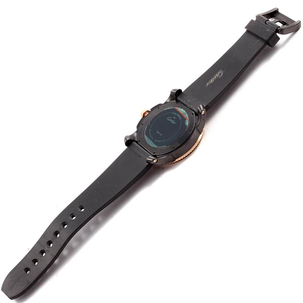 The image shows the back view of a Calibre de Cartier watch by Cartier, including the case back and the rubber strap.