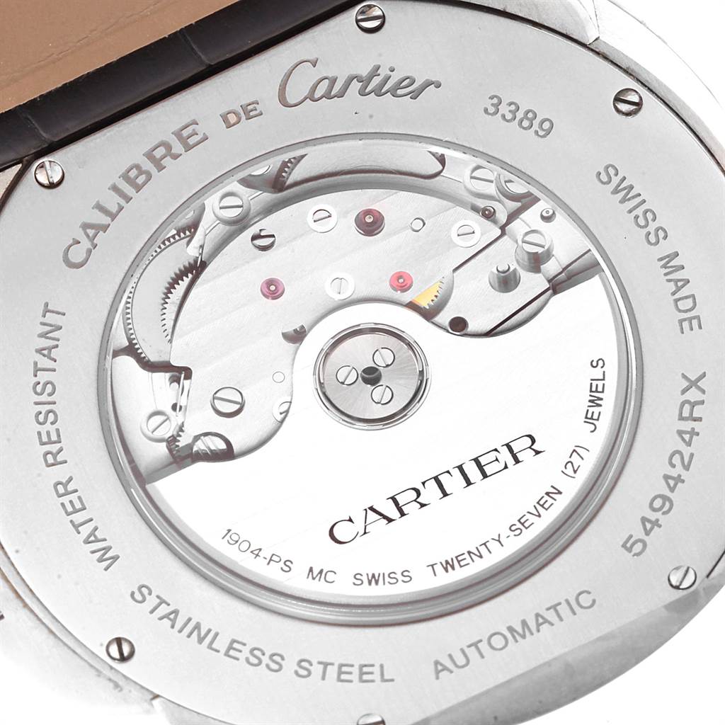 The image shows the back of the Calibre de Cartier watch by Cartier, revealing its automatic movement and inscriptions.