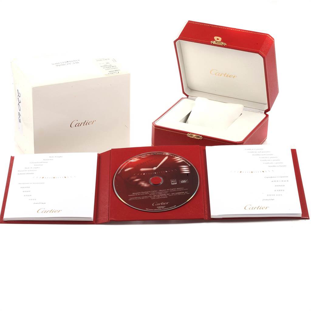 The image shows the packaging, manuals, CD, and red box of a Calibre de Cartier watch by Cartier.