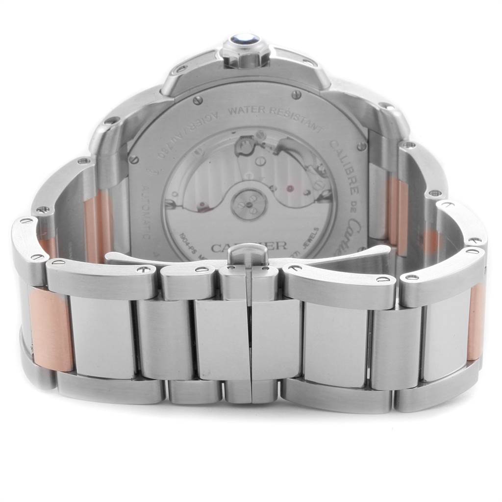 The image shows the back view of a Calibre de Cartier watch by Cartier, highlighting its steel and rose gold bracelet and transparent case back.