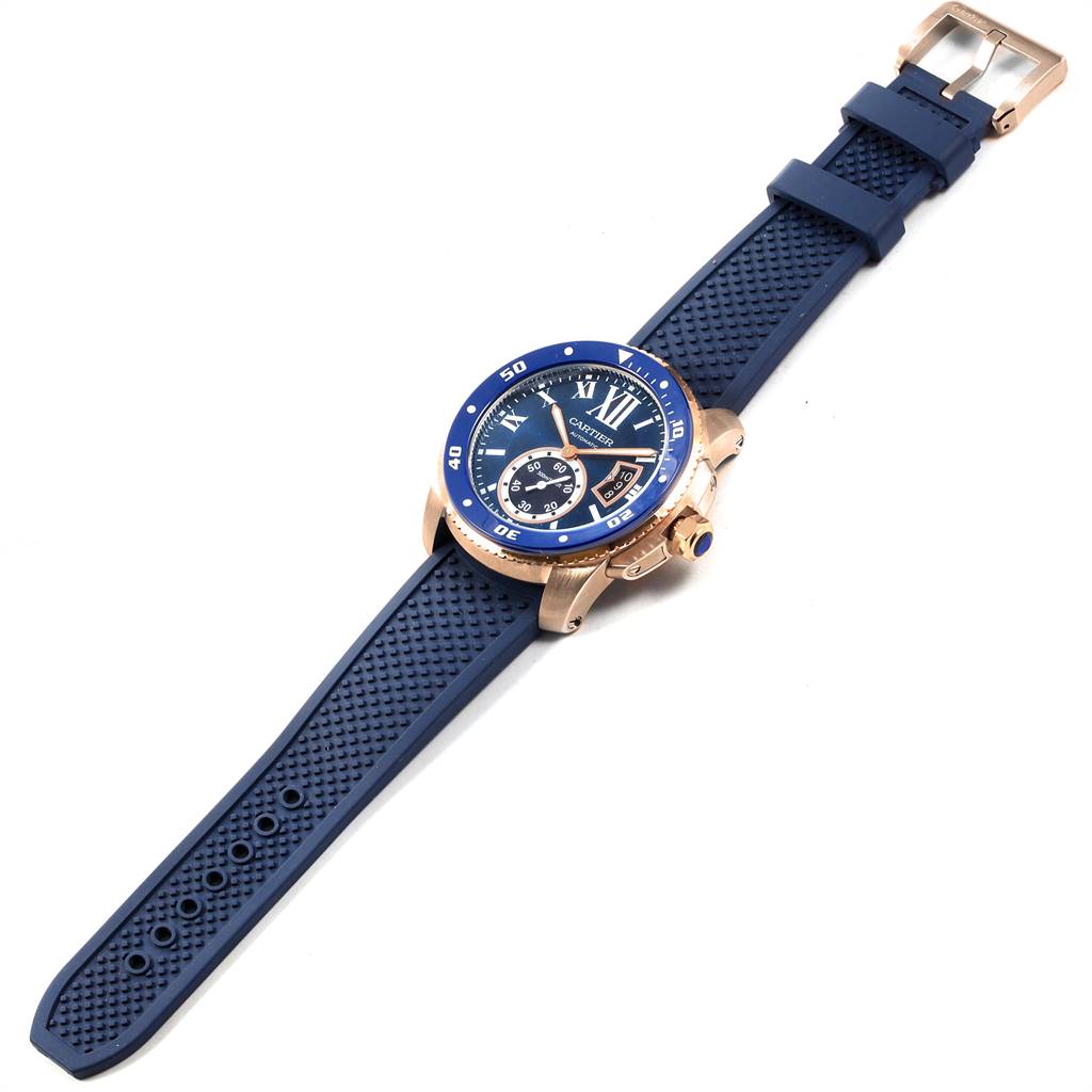 The Calibre de Cartier watch by Cartier is shown at an angled view, displaying the face, bezel, straps, and buckle.