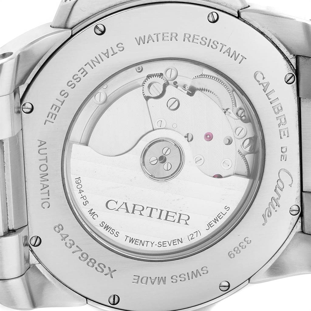The image shows the back view of the Calibre de Cartier watch by Cartier, displaying its automatic movement through a transparent caseback.