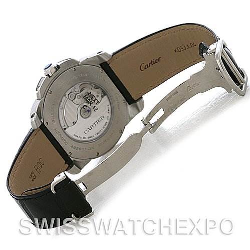 The image shows the rear view of a Calibre de Cartier watch by Cartier, highlighting its open case back, leather strap, and deployment clasp.