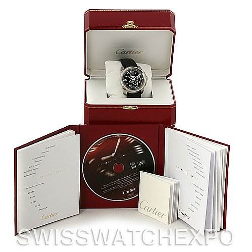 The image shows a Calibre de Cartier watch by Cartier in its box, accompanied by manuals and a CD, all arranged neatly.