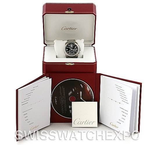 The image shows the Cartier Calibre de Cartier W7100016 Men's Stainless Steel Black Dial W7100016 Men's Stainless Steel Black Dial watch in its open box, alongside manuals and a CD, displaying an angle from the front.