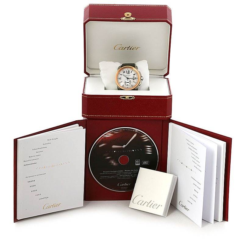 The image shows the Calibre de Cartier watch in its open box with accompanying manuals and a CD.