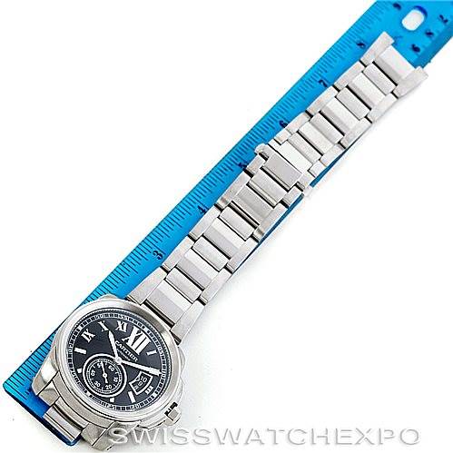 The image shows a top-down view of a Calibre de Cartier watch by Cartier, placed next to a ruler for scale.