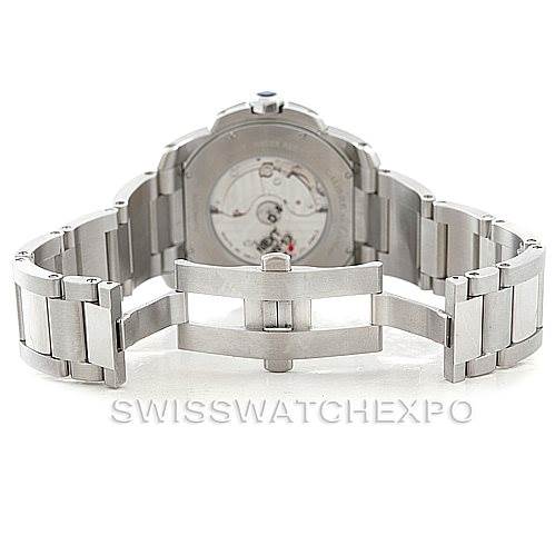 The image shows the back view of the Calibre de Cartier watch by Cartier, highlighting its open automatic movement and metal bracelet.