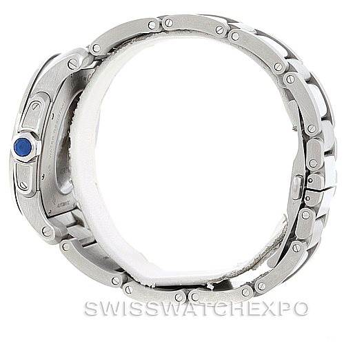 This side view of the Calibre de Cartier watch by Cartier shows the metal bracelet and crown, featuring a blue gemstone.