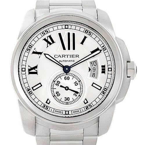 The image shows the face of the Calibre de Cartier watch by Cartier, displaying Roman numerals, a central dial, and a date window at 3 o'clock.