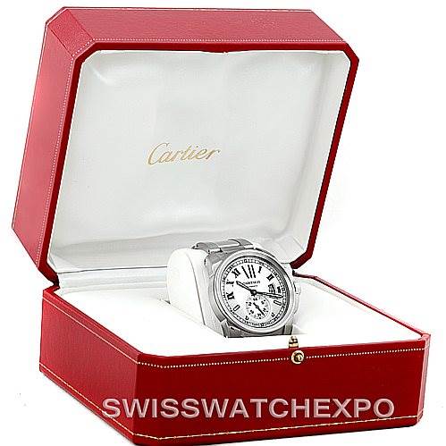 The image shows a Calibre de Cartier watch by Cartier placed at an angle inside an open red Cartier display box.